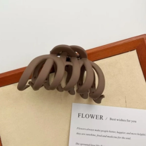 Close-up of a large coffee brown matte hair claw clip with interlocking teeth for hair styling