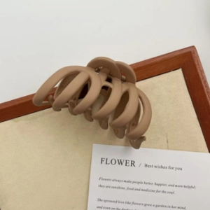 Detail of a large matte coffee hair claw clip showing smooth texture and strong teeth