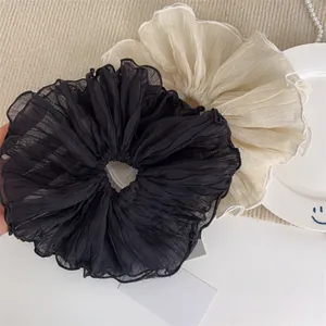 Detail of elegant black and cream pleated hair scrunchies with soft fabric textures