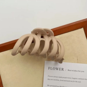 Detail view of a large matte brown shark hair claw clip for elegant bun hairstyles