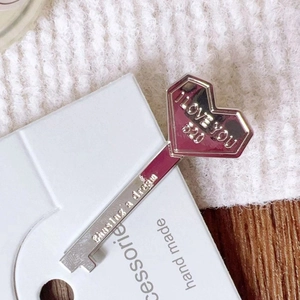 Macro shot of silver key-shaped metal hair clip with I LOVE YOU and 520 engravings