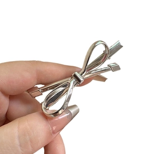 French minimalist silver bow hair clip with sleek metal finish and duckbill grip