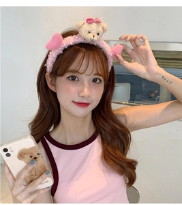Détail d'un bandeau en peluche rose avec un ourson 3D et des décorations d'oreilles