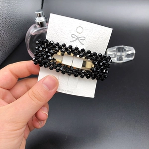 Detail der rechteckigen Haarspange mit schwarzen Facettenperlen und goldener Basis