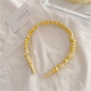 Elegant pale yellow pleated satin headband for women featuring a minimalist U-shaped design