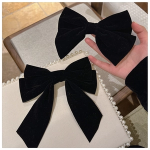 Detail of premium black velvet bow hair clip showing high-quality fabric texture