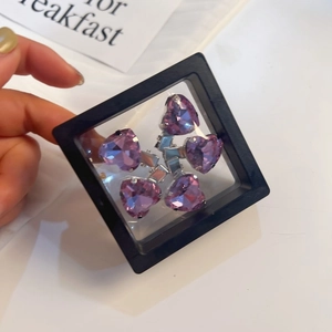 Detail van vijf paarse hartvormige strass haarspelden in een zwarte display doos