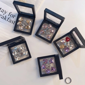Detailopname van sprankelende hartvormige strass haarspelden in zwarte geschenkdozen