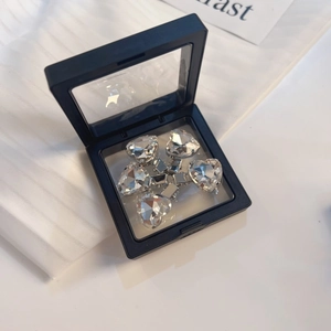 Detail van vijf roze strass hart haarspelden in een zwarte PE-membraan sieraden opbergdoos