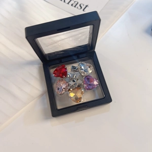 Set van kleurrijke hartvormige strass haarspelden in een zwart zwevend frame