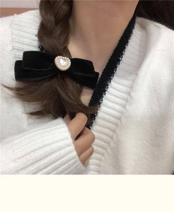 Detail of vintage black velvet bow hair clip with heart pearl and golden relief trim