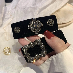 Macro view of black velvet hair clip featuring grey rhinestones and vintage baroque details