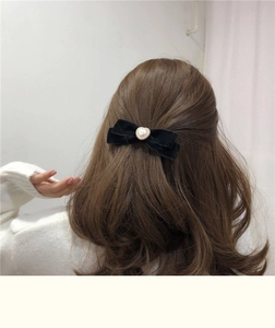 Detail of vintage black velvet bow hair clip with heart pearl on back of model hair
