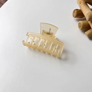 Macro detail of amber matte jelly hair claw clip with frosted resin texture and grip teeth