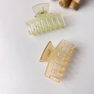 Detail of matte translucent resin hair claws in light green and amber finish