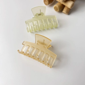 Detail of matte jelly-colored small hair claws in translucent green and khaki colors