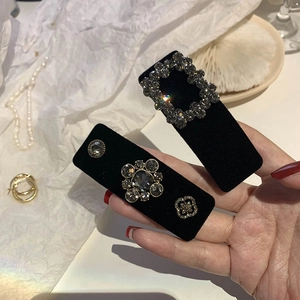 Detailed shot of black velvet hair clips with sparkling rhinestones and vintage gemstones