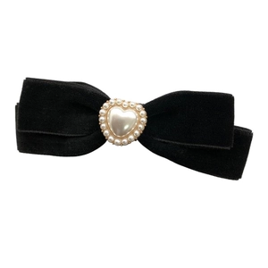 Vintage black velvet bow hair clip with a white heart pearl ornament on white background