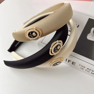 Detail of satin headbands with golden rose relief and imitation pearl decorations