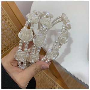 Detail view of double-layered pearl headband with 3D white resin rose flowers