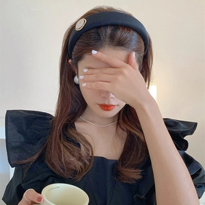 Detail of a padded black velvet headband with elegant pearls on a female model