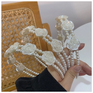 Detail shot of vintage pearl headband featuring white resin roses on double-row pearls