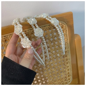 Detailed view of vintage resin rose flower and double-row white pearl headband for women