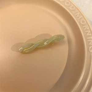 Detail view of light green marble texture twist hair clip on beige embossed tray