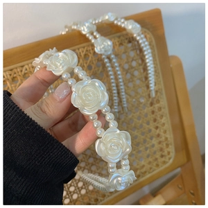 Detailed view of dual-layer white pearl headband featuring delicate acrylic roses