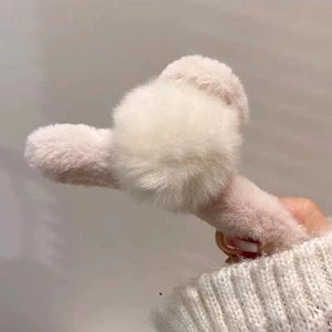 Détail d'une pince à cheveux en fausse fourrure douce avec un pompon blanc mignon