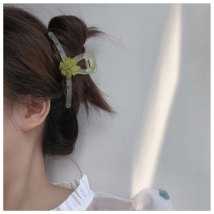 Détail de la pince à cheveux muguet vert forêt sur la chevelure d'une femme élégante