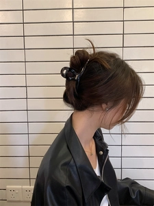 Détail d'une grande pince à cheveux noire brillante pour cheveux épais sur un modèle