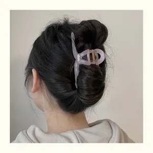 Vue détaillée d'une grande pince à cheveux en résine lavande sur un chignon bas