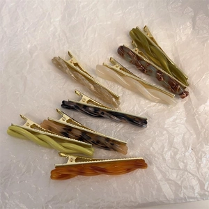 Set of 8 twisted acetate hair clips in leopard, amber, and cream with gold metal clips