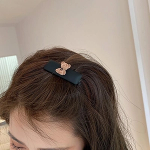 Detail showing a cute brown flocked bear hair clip worn on the side of the head
