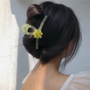 Détail de la pince à cheveux muguet vert forêt sur la coiffure élégante du mannequin