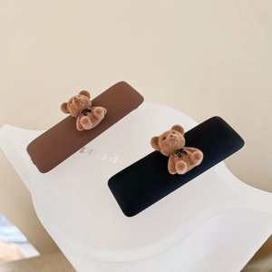 Detailed view of cream and coffee colored bear hair clips with velvet bow accents