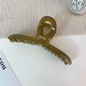 Détail d'une pince à cheveux vert olive translucide avec texte blanc Barrette La France