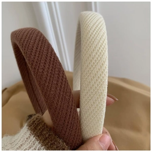 Detailed close-up of waffle textured sponge headbands in dark brown and creamy white