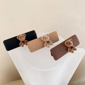 Detail of matte hair clips featuring cute teddy bears in black, beige, and dark brown