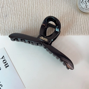 Grosse pince à cheveux noire brillante avec lettrage Barrette La France doré en gros plan