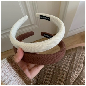 Detail of cream and brown padded sponge headbands with twill fabric and handmade labels