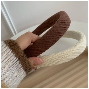 Detailed view of thick knitted sponge headbands in brown and beige with ribbed texture