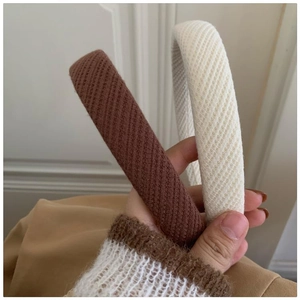 Detail of dark brown and beige knitted sponge headbands with non-slip inner lining