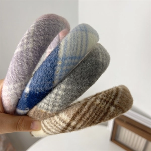 Detailed close-up of plaid wool headbands with gold thread and fuzzy mohair texture