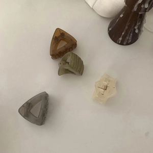 Minimalist geometric matte hair clips in amber and grey tones for ponytail styling