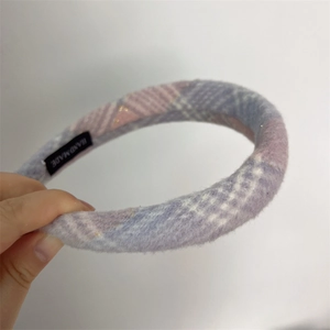 Close-up of handmade pink plaid knitted headband with soft fuzzy texture detail