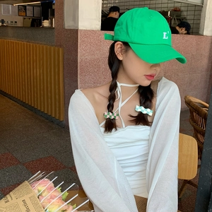 Detail of green cotton baseball cap with white embroidered L letter on a model