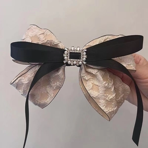 Detail der doppellagigen Schleifen-Haarspange mit Crinkle-Stoff und Perlen-Strass-Schnalle