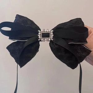 Detail einer schwarzen Schleife Haarklammer mit Spitze, Perlen und Glitzersteinen